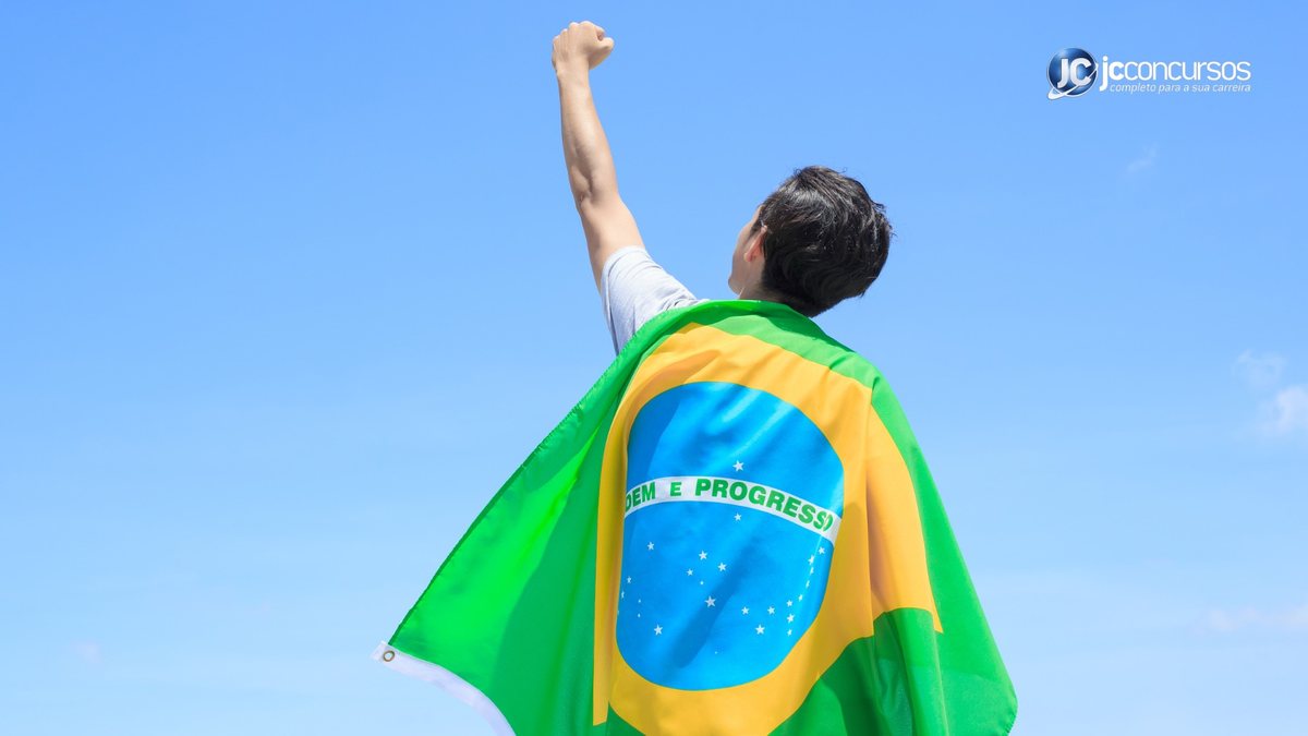 Jovem vestido com a bandeira do Brasil