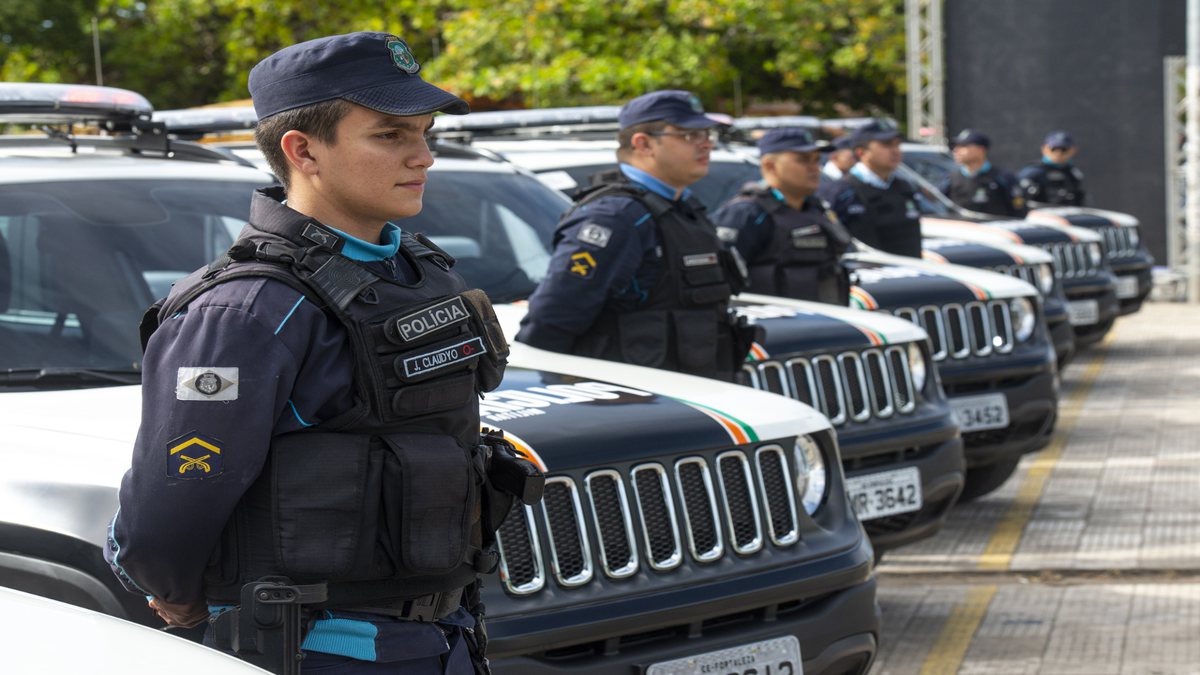 Concurso PM CE: soldados da Polícia Militar do Ceará perfilados ao lado de viaturas