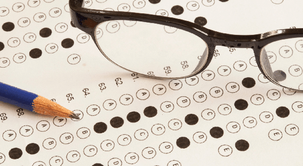 Concurso Futel: lápis e óculos em cima de folha de resposta de prova - Divulgação