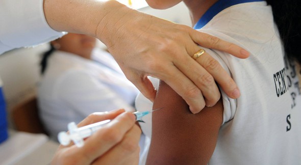 Profissional da saúde aplica vacina em paciente - EBC