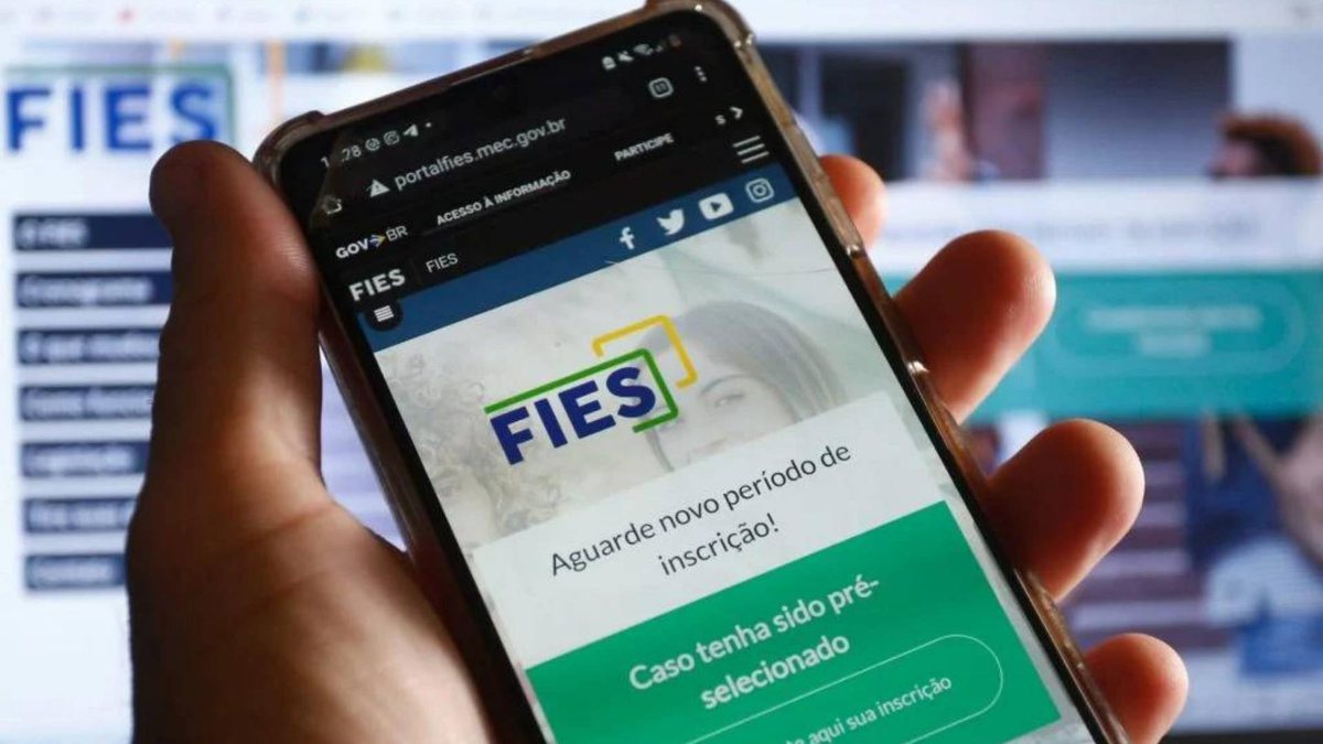 Homem segura celular aberto com site do Fies - Agência Brasil