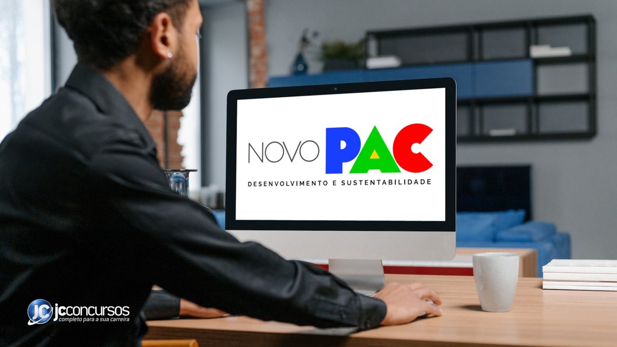 Homem de frente a um monitor com a logo do Novo PAC - Divulgação JC Concursos